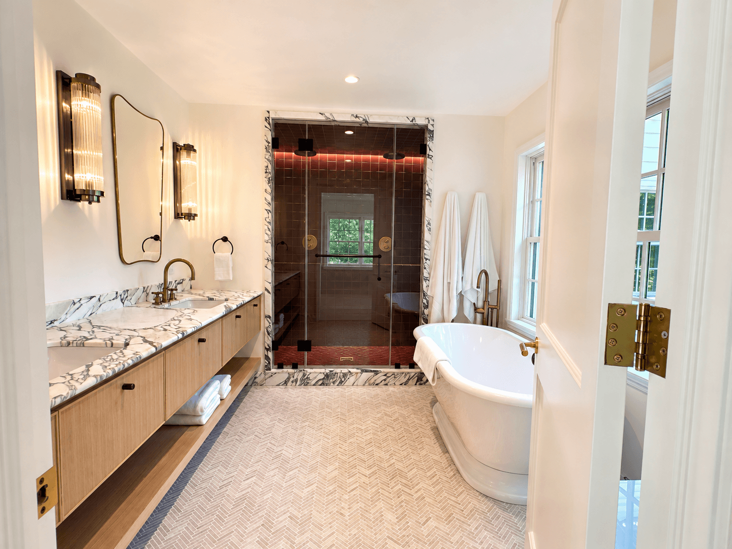 Primary bath with marble double vanity, freestanding tub, and shower surround