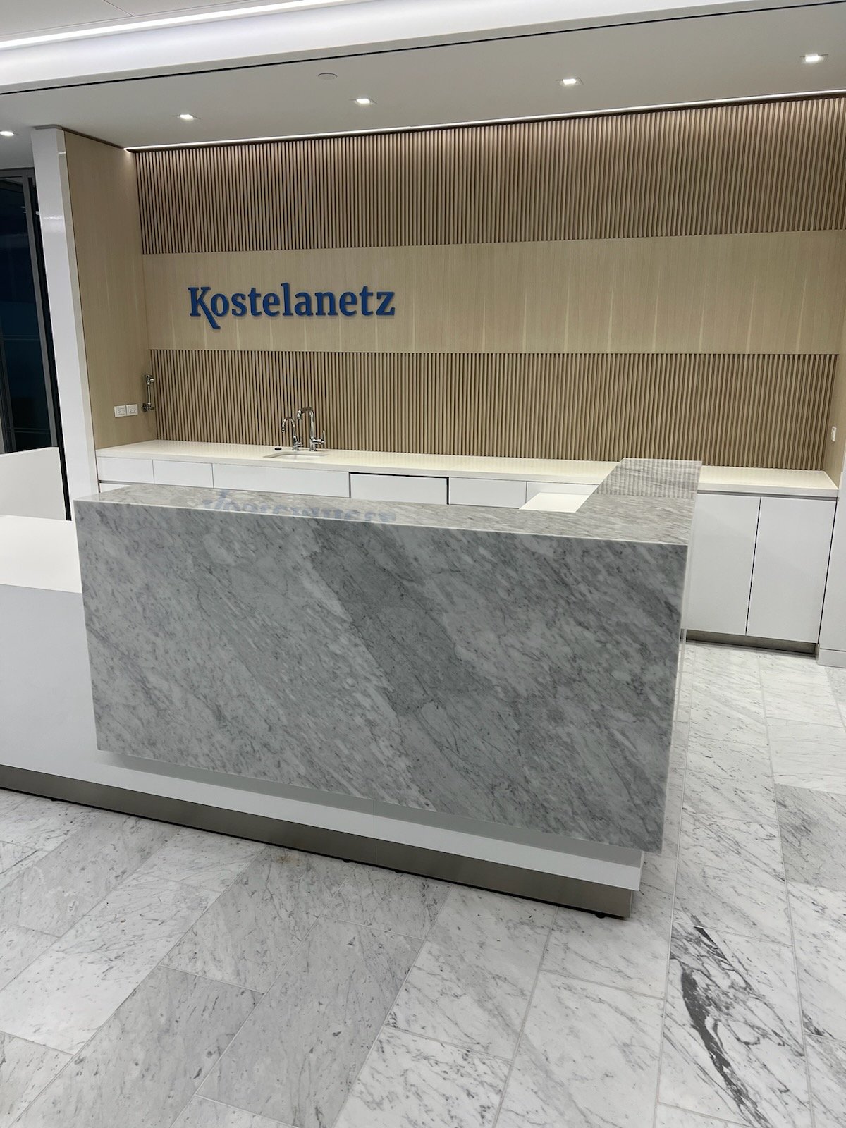 Reception desk with Kostelanetz signage wall