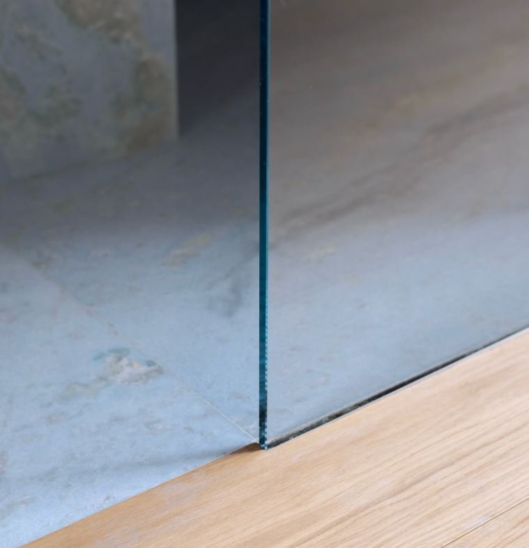 Marble slab floor seam at the glass shower door threshold