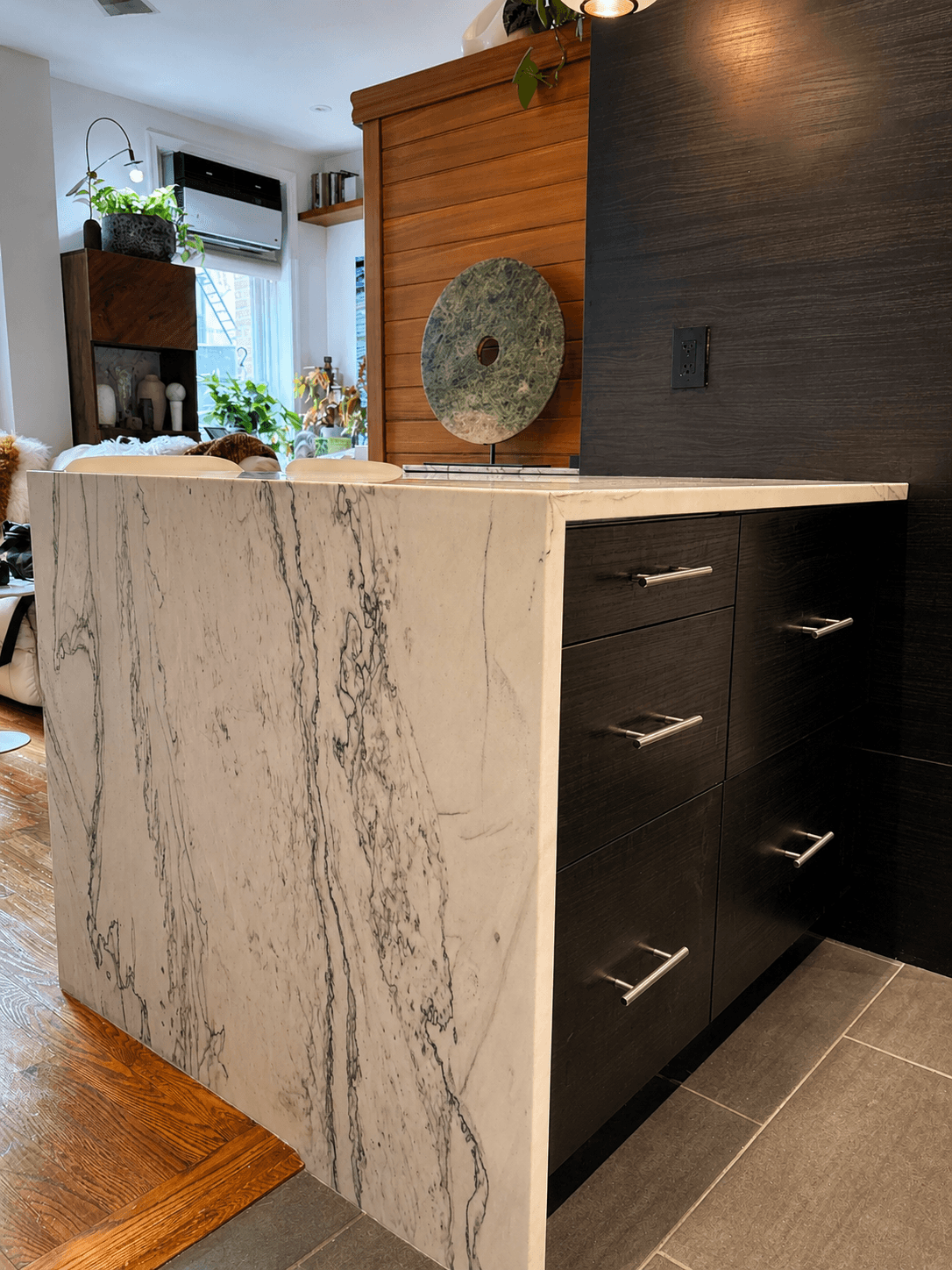 Waterfall island edge with black cabinetry and drawers