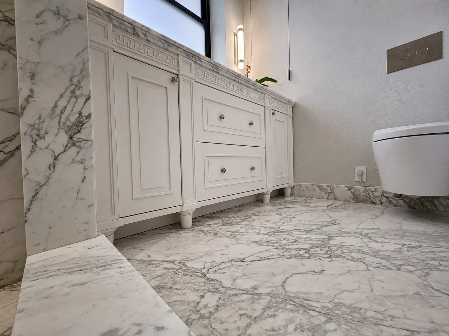 Primary bath with Calacatta Monet shower, vanity, and marble flooring