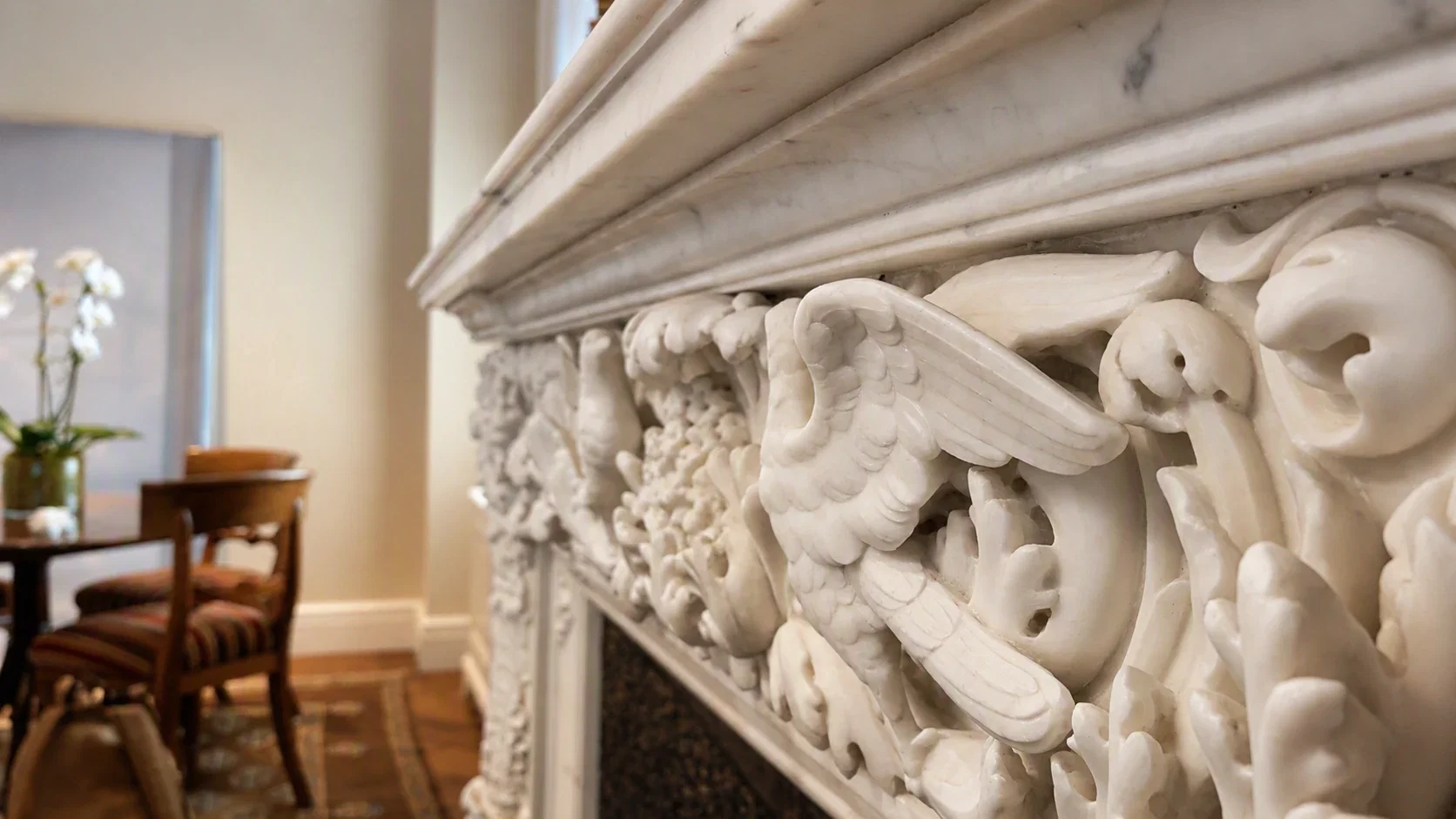 Carved marble frieze detail on the fireplace mantel